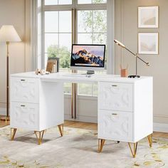 a white desk with two drawers and a computer monitor on it in front of a window