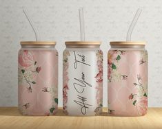 three pink floral tumblers with straws in them