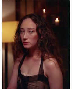 a woman with curly hair wearing a black dress