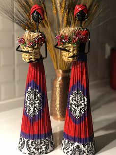 two red and blue vases sitting next to each other on top of a table