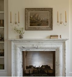 a fireplace with a painting on the wall above it