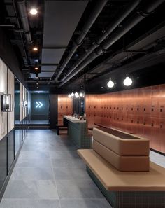 an empty public restroom with benches and lockers