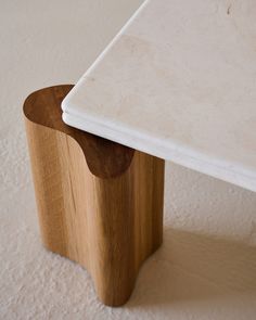 a close up of a wooden table with a white marble top on the bottom and side