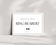 a white poster with the words ring bearer on it and a bow tie in black