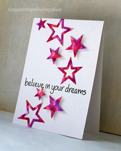 a card with pink stars on it and the words believe in your dreams written below