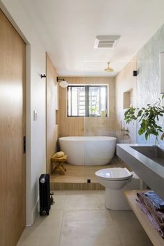 a bathroom with a tub, toilet and sink in it's centerpieces