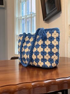 a crocheted bag sitting on top of a wooden table