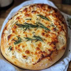 a baked bread with cheese and herbs on it sitting on a napkin next to a cup