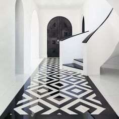 a black and white hallway with an intricate design on the floor