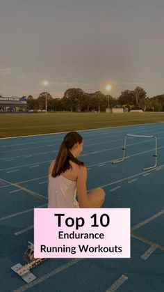 a woman sitting on top of a tennis court holding a racquet