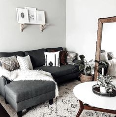 a living room filled with furniture and a large mirror on the wall above it's headboard