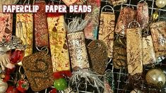 many different types of paper beads hanging on a wire rack with the words paperclip paper beads above them