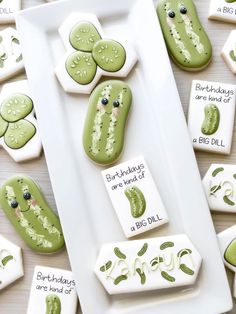 cookies decorated with green and white frosting are on a plate next to cards that say birthdays are end of a big dill