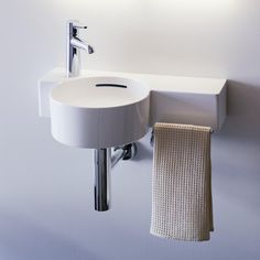 a bathroom sink with a towel hanging on the wall next to it's faucet