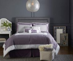 a bed room with a neatly made bed next to a dresser and mirror on the wall