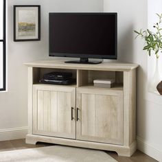 an entertainment center with a flat screen tv on it's stand in a living room