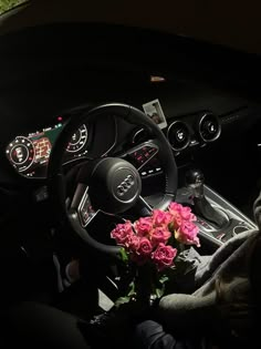 the interior of a car with pink roses in the center and steering wheel on display