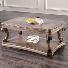 a coffee table sitting on top of a wooden floor next to a bowl of fruit