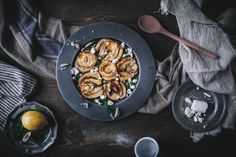 a plate filled with food on top of a table next to two bowls and spoons