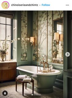 the bathroom is decorated in green and gold with white flowers on the wall, along with an antique claw foot tub