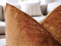 two brown pillows sitting on top of a white couch