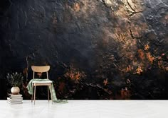 a chair sitting on top of a white floor next to a wall covered in black and gold paint