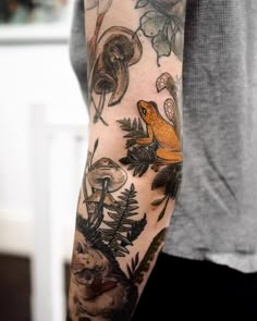 a person with a tattoo on their arm and some animals in the woods behind them