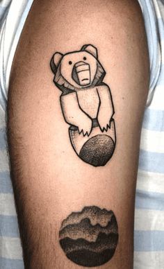 a man with a tattoo on his arm that has a bear and mountain in the background