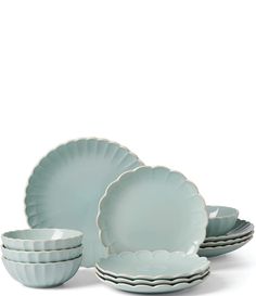 a set of four plates and bowls with scalloped rims in pale blue