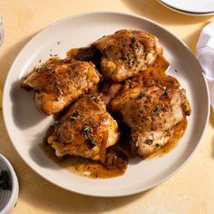 some chicken on a white plate with herbs