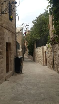 an alley way with stone buildings and trees