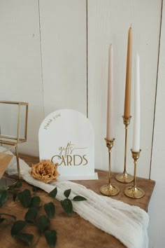 a table topped with candles and cards on top of a wooden table