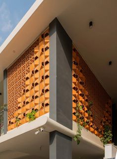 an orange and grey building with plants growing on the side