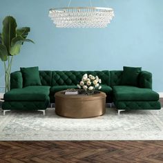 a living room with green couches and a chandelier