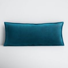 a teal blue pillow on a white background