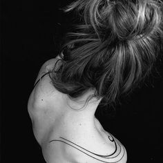 black and white photograph of a woman with tattoos on her back