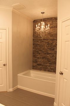 a bathroom with a chandelier hanging from the ceiling and a bathtub next to it