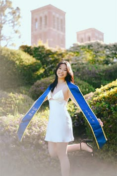 a woman in a white dress holding a blue and yellow scarf