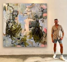 a man standing in front of a large painting