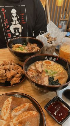 a person sitting at a table with bowls of food