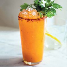 an orange drink with garnish on the rim