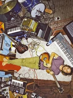 a woman laying on the floor surrounded by musical instruments