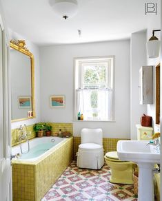 a bathroom with a tub, sink, and toilet in the middle of the room