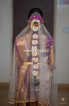 a woman wearing a veil with flowers on it