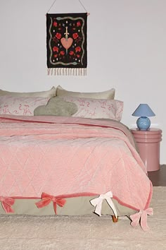 a bed with pink bedspread and pillows on it