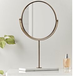 a round mirror sitting on top of a white counter