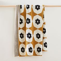 two towels hanging on a clothes line with black and white flower designs in the middle