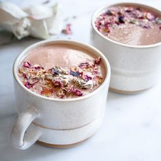 two white mugs filled with hot chocolate and flowers