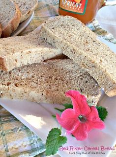 two pieces of bread sitting on top of a white plate next to a pink flower