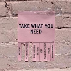 a pink piece of paper taped to the side of a wall with words written on it